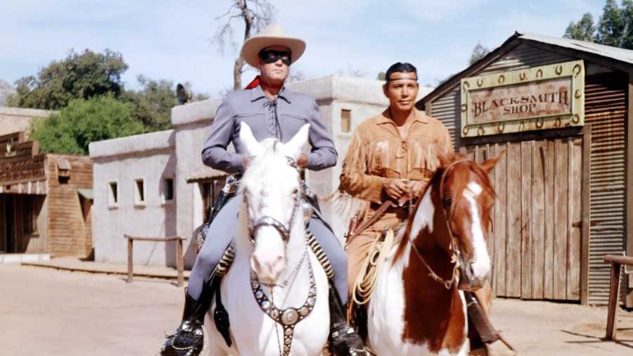 Clayton Moore portrays the Lone Ranger with his bluish-gray costume, white cowboy hat and black mask alongside Jay Silverheels.