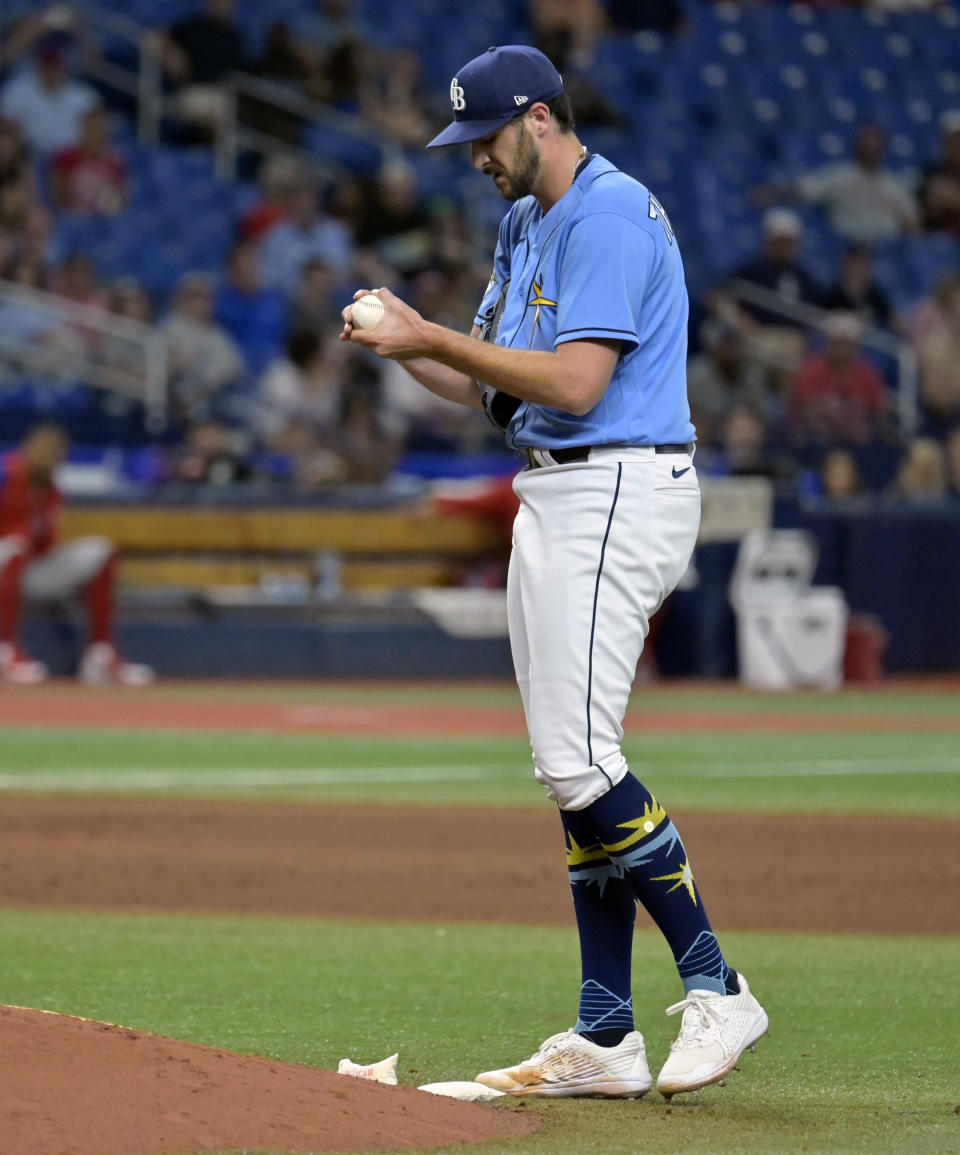 Tampa Bay Rays reliever Ryan Thompson rubs a new ball after giving up two go-ahead runs during the 11th inning of a baseball game against the Philadelphia Phillies, Thursday, July 6, 2023, in St. Petersburg, Fla. (AP Photo/Steve Nesius)