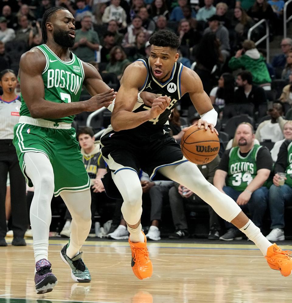 Boston Celtics guard Jaylen Brown (7) defends Milwaukee Bucks forward Giannis Antetokounmpo (34) on Tuesday night. Antetokounmpo left the game later with a left soleus strain.