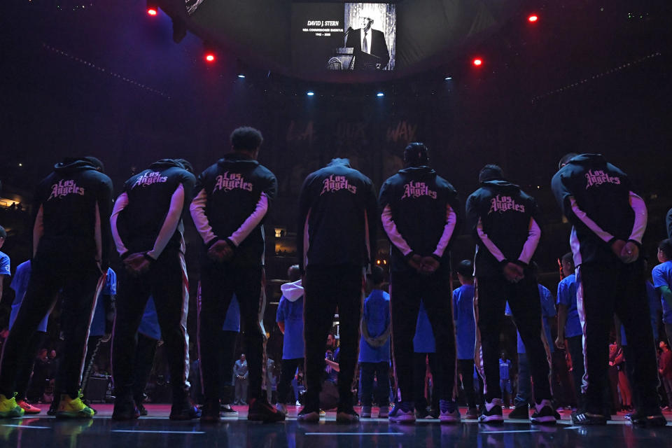 Members of the Los Angeles Clippers stand duringa a moment of silence Thursday, Jan. 2, 2020, in Los Angeles, prior to a basketball game against the Detroit Pistons, for former NBA Commissioner David Stern, who died Wednesday as a result of the brain hemorrhage. (AP Photo/Mark J. Terrill)