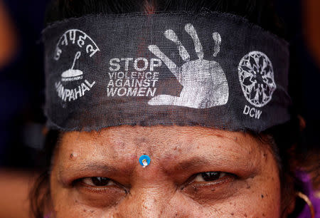 FILE PHOTO: A woman wears a bandana with a message, during a protest organised by the Delhi Commission for Women, against the rape of an eight-year-old girl, in Kathua, near Jammu and a teenager in Unnao, Uttar Pradesh state, in New Delhi, India April 13, 2018. REUTERS/Saumya Khandelwal