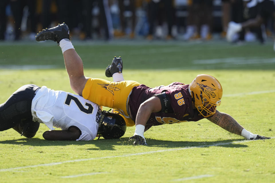 Arizona State defensive lineman Anthonie Cooper (96) knocks over Colorado quarterback Shedeur Sanders (2) during the first half of an NCAA college football game Saturday, Oct. 7, 2023, in Tempe, Ariz. (AP Photo/Ross D. Franklin)