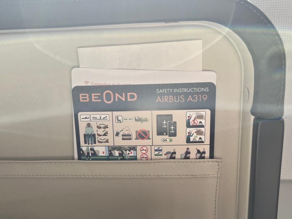 The Airbus A319 safety instructions card in the seat pocket of a Beond airliner