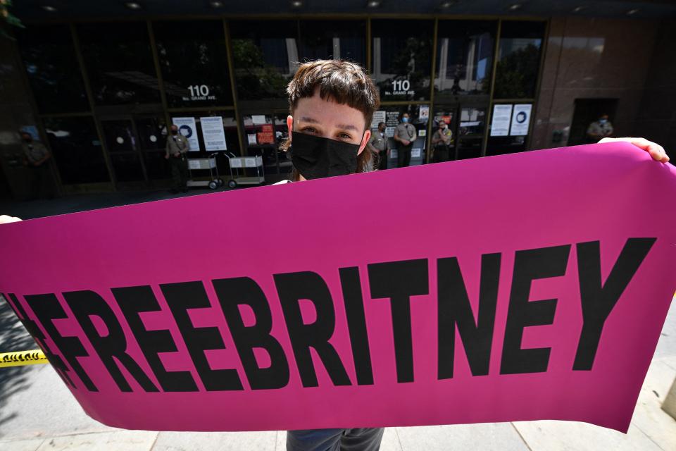 A fan holds a "#FreeBritney" banner as supporters of Britney Spears gather outside the Los Angeles County Courthouse in Los Angeles, on July 14, 2021, during a scheduled hearing in her guardianship case.