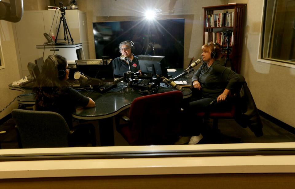 Three people in a radio booth