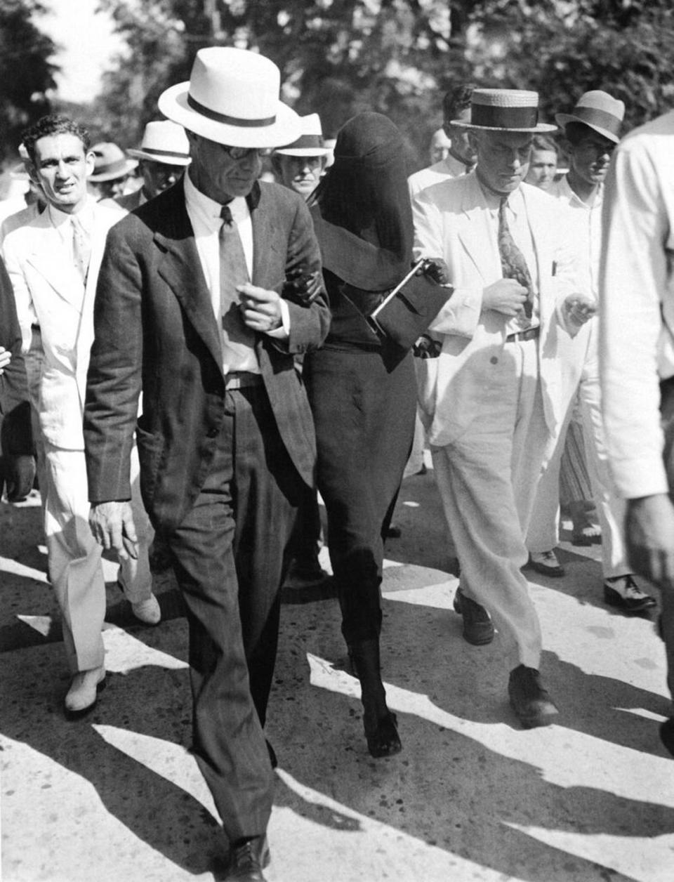 Libby Holman Reynolds, attired in mourning dress with her father, Alfred Holman, left, Cincinnati, Ohio, lawyer, as they left the courthouse at Wentworth, N.C., Aug. 8, 1932, after her release on $25,000 bond to await trail on an indictment charging her and Ab Walker, friend, with the murder of her husband, Smith Reynolds, tobacco heir. (AP Photo)