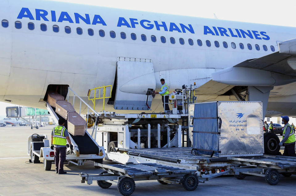 In this handout photo released by the Afghanistan Foreign Ministry, airport workers unload bodies of Afghans from the Ariana Afghan Airlines at the Kabul International Airport in Kabul, Afghanistan, Wednesday, May 24, 2023. The bodies of 18 Afghan migrants who died while being smuggled into Bulgaria were returned to Afghanistan’s capital, Kabul, on Wednesday, a spokesman for the Taliban government's Foreign Ministry said. (Afghanistan Foreign Ministry via AP)