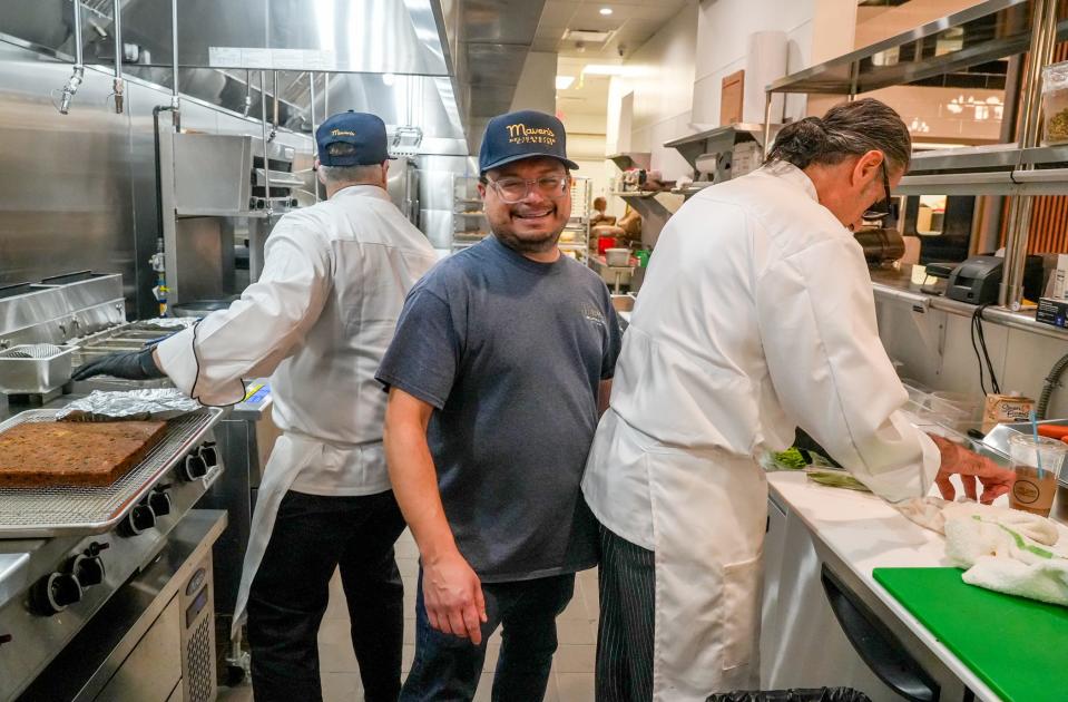 The kitchen is busy during a press preview at Maven's Delicatessen in Pawtucket's Blackstone Plaza. Owner Jason Sugarman is pictured in the center of his chefs.