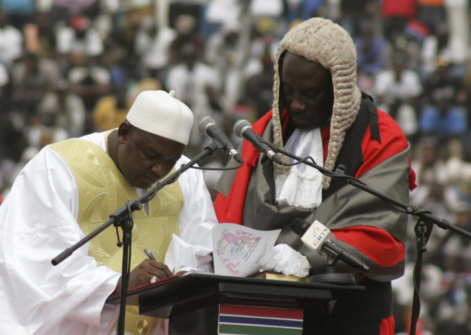 In this photo taken on Saturday, Feb. 18, 2017, Gambia President Adama Barrow, left, signs a document during his inauguration ceremony in Banjul, Gambia. As Gambia enters a new era of democracy, President Adama Barrow has reiterated his commitment to ending human rights abuses in the country. (AP Photo/Kuku Marong)