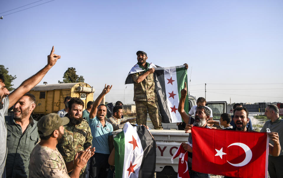 Turkish-backed Syrian opposition fighters celebrate in Akcakale, in Sanliurfa province advance, after entering over the border from Tal Abyad, Syria, Sunday, Oct. 13, 2019. State-run Anadolu news agency reported Tal Abyad had fallen to a Turkish military offensive on Sunday. (AP Photo/Cavit Ozgul)