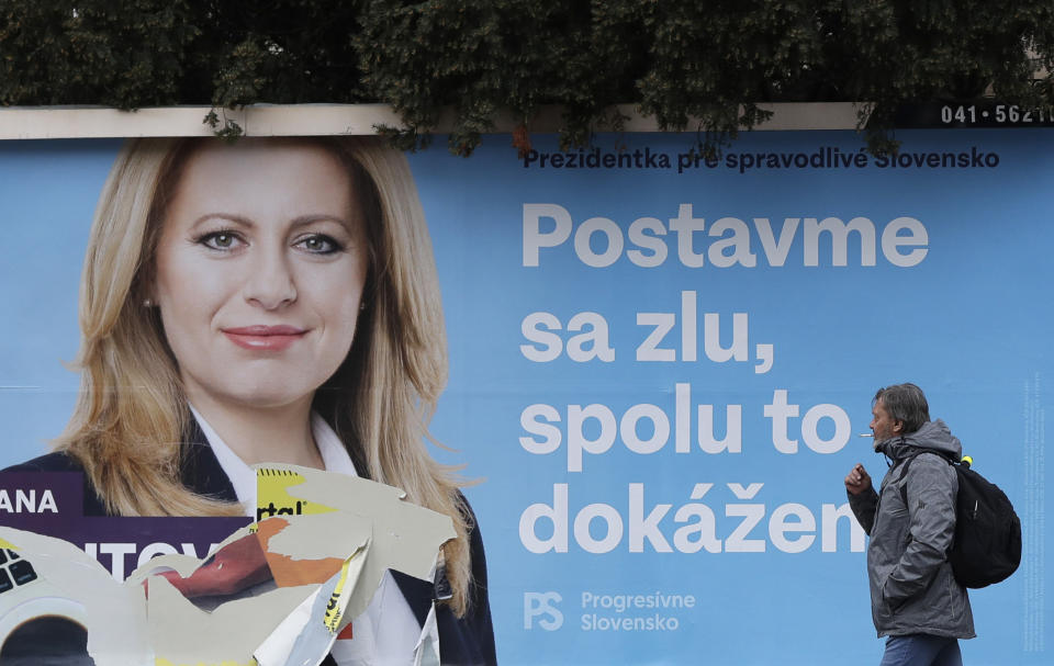 In this file photo taken on Friday, March 15, 2019, a man walks past a campaign poster for Zuzana Caputova in Bratislava, Slovakia. Slovakia could get its first woman president as voters elect a new head of state on Saturday March 30. The leading contenders are Zuzana Caputova, an environmental activist who is in favor of gay rights and opposes a ban on abortion in this conservative Roman Catholic country, and Maros Sefcovic, an establishment figure who is the European Commission Vice-President. The poster reads: "Let's stand against evil, together we can make it."(AP Photo/Petr David Josek/File)