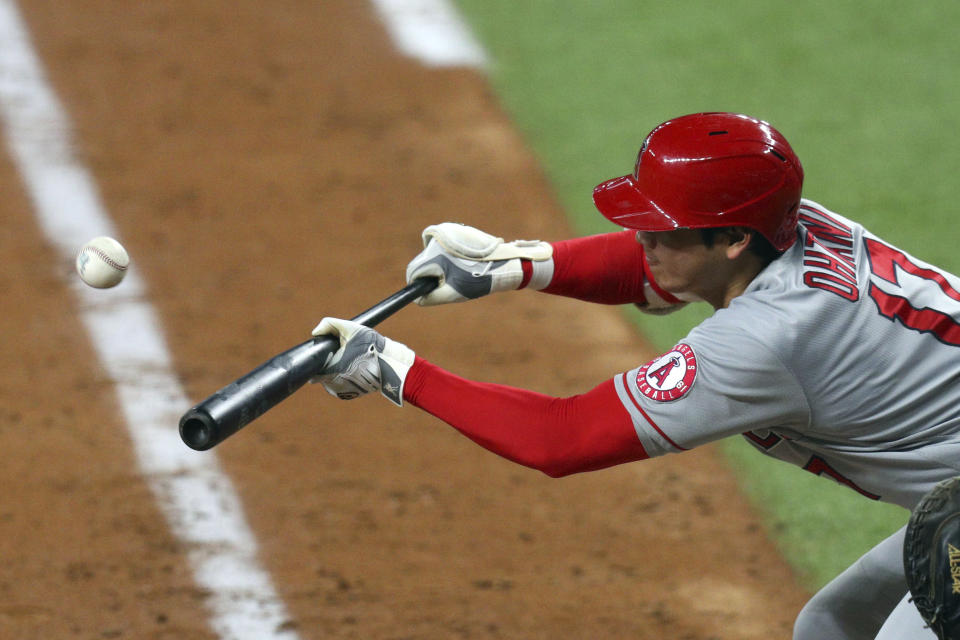 Los Angeles Angels starting pitcher Shohei Ohtani bunts his way on base against the Texas Rangers in the sixth inning during a baseball game on Monday, April 26, 2021, in Arlington, Texas. (AP Photo/Richard W. Rodriguez)