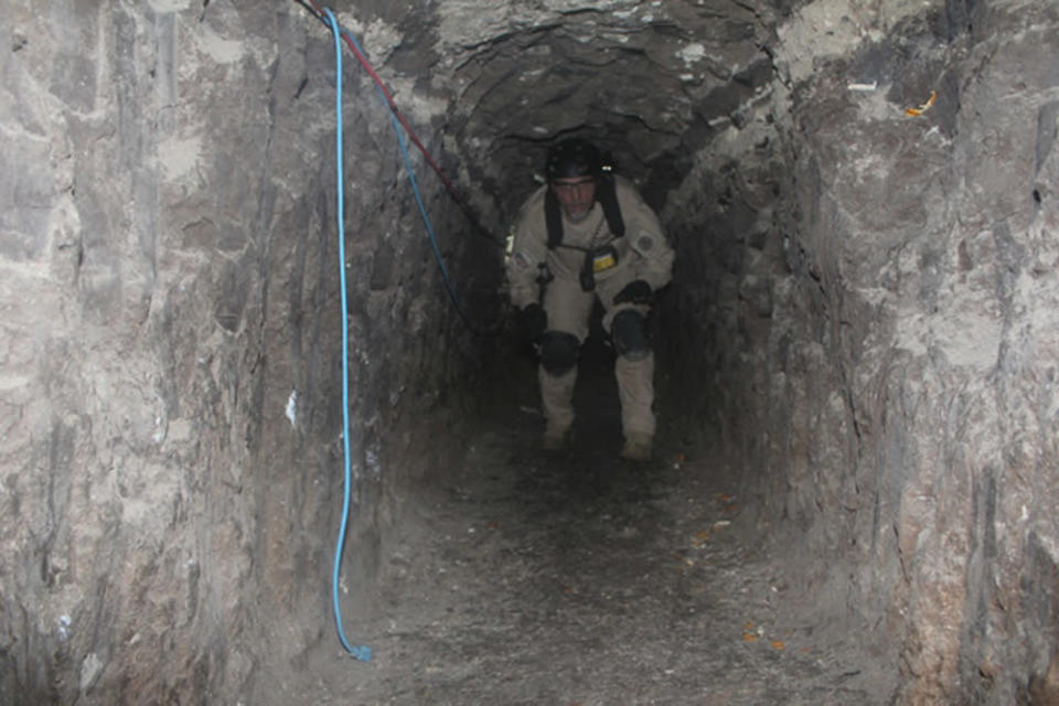 An agent from the San Diego Tunnel Task Force walks through part of the passageway of a tunnel found under the U.S.-Mexico border, in San Diego, November 26, 2010. REUTERS/U.S. Immigration and Customs Enforcement (ICE)/Handout