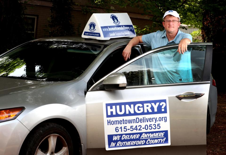 John Garrett the owner and founder of Hometown Delivery stands next to his vehicle that he uses to deliver meals on Wednesday, Sept. 16 2020.