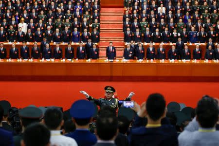 A conductor leads an orchestra as delegates stand for the national anthem during the closing session of the 19th National Congress of the Communist Party of China at the Great Hall of the People in Beijing, China October 24, 2017. REUTERS/Thomas Peter