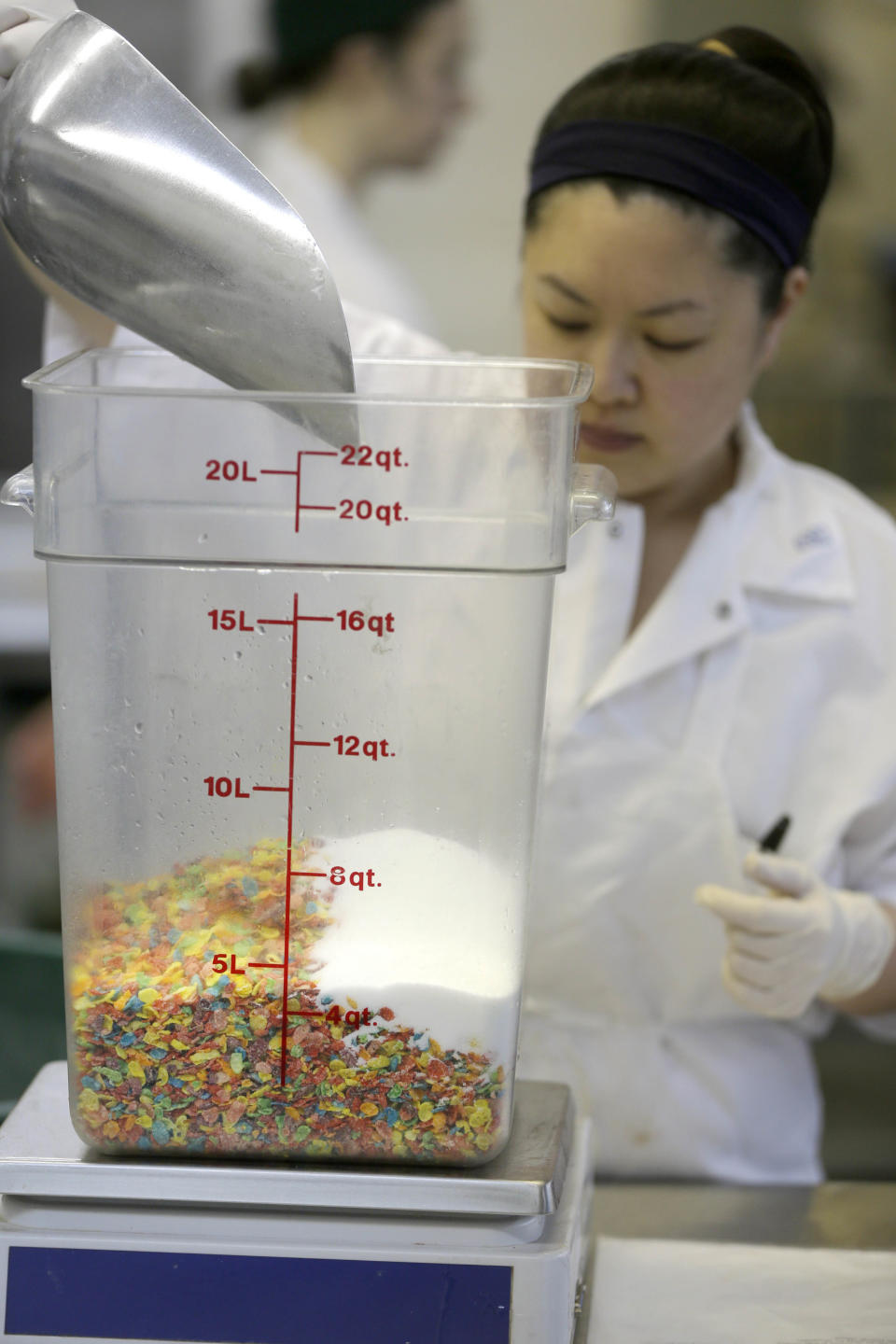 In this Thursday, Feb. 21, 2013 photo, Angiel Tran makes fruity cereal milk using Fruity Pebbles cereal at the Milk Bar kitchen in New York. Cereal is going out of the box. Milk, ice cream, muffin mix and more are being infused with the flavor of the classic childhood treat. (AP Photo/Seth Wenig)