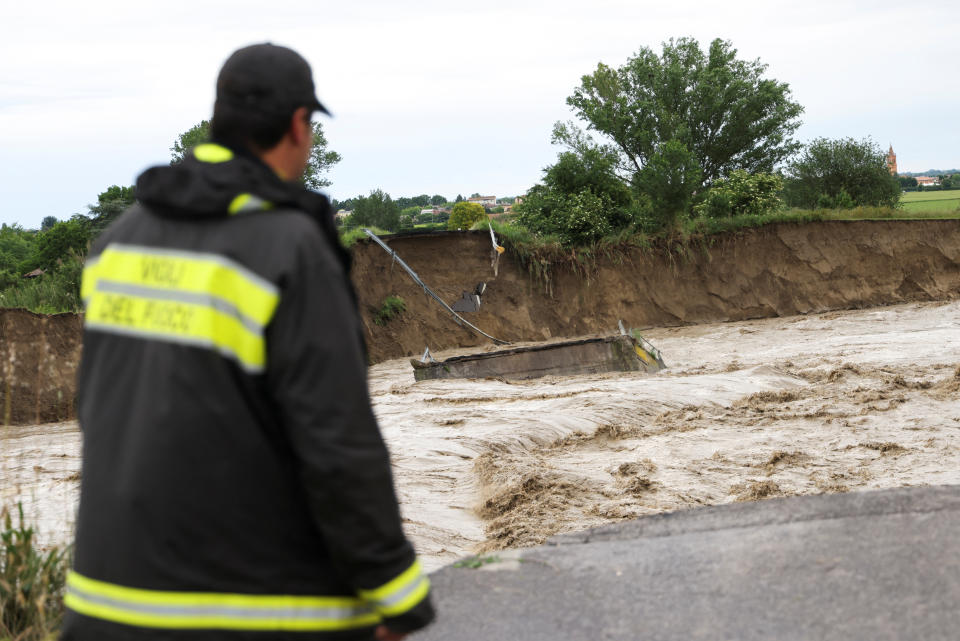 A person looks at a collapsed bridge in the aftermath of the downpour. (Reuters)