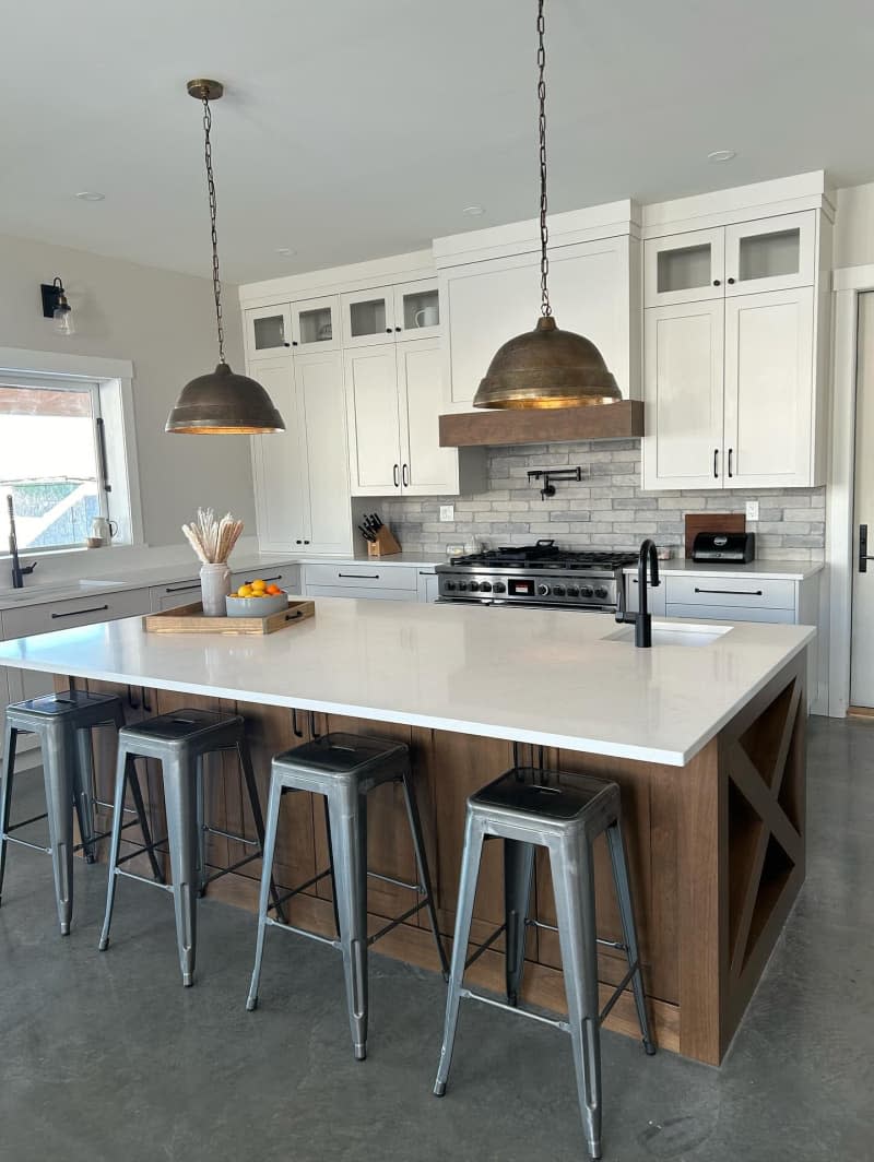 white farmhouse style kitchen with wood island and metal stools