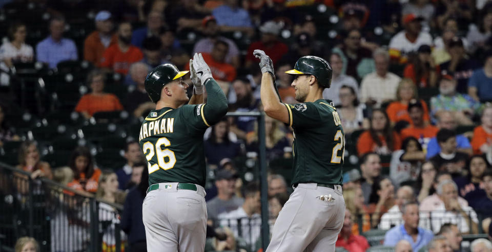 Oakland Athletics' Matt Olson, right, celebrates with Matt Chapman (26) after both scored on Olson's home run against the Houston Astros during the fourth inning of a baseball game Tuesday, Sept. 10, 2019, in Houston. (AP Photo/David J. Phillip)