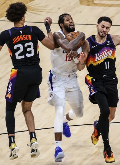 Clippers forward Paul George tries to split the defense of Phoenix's Cameron Johnson and Abdel Nader during Game 5.