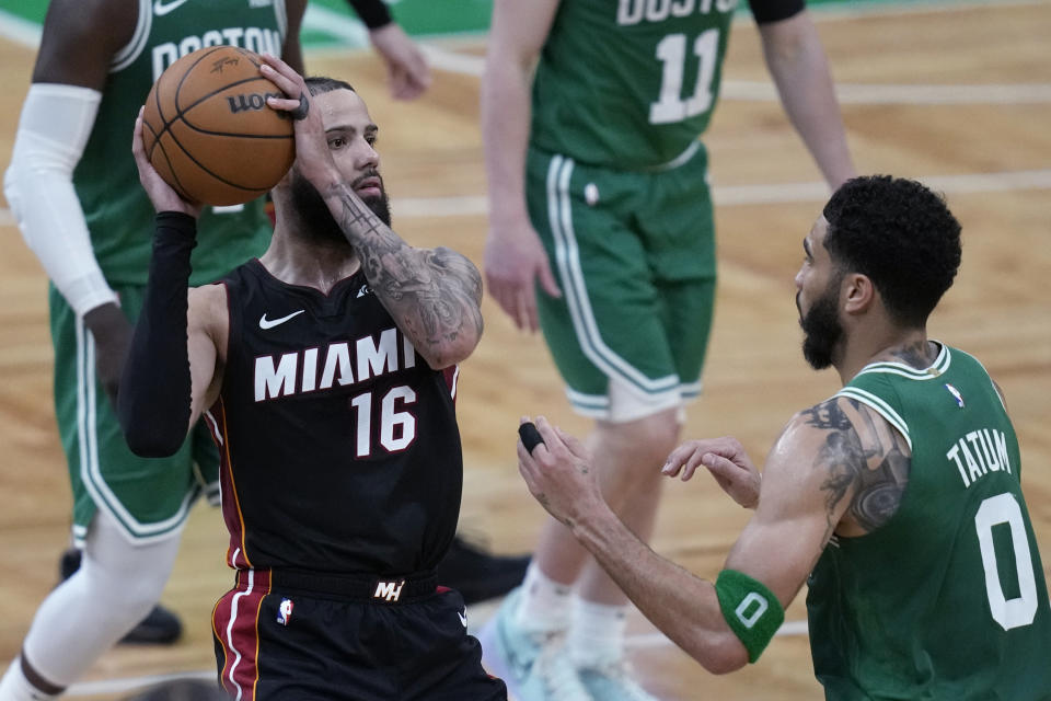 Miami Heat forward Caleb Martin (16) looks to pass while defended by Boston Celtics forward Jayson Tatum (0) during the second half Game 2 of an NBA basketball first-round playoff series Wednesday, April 24, 2024, in Boston. (AP Photo/Charles Krupa)