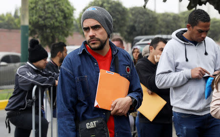 Venezuelan migrants wait at the Interpol headquarters to get paperwork needed for a temporary residency permit, in Lima, Peru, August 16, 2018. REUTERS/Mariana Bazo