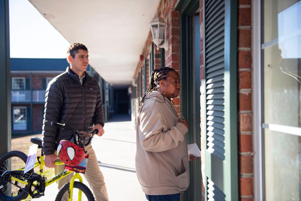 Drew Brannon, YMCA of Greenville volunteer, carries a bike for Tauranda Glenn for her family for Christmas at Greenville Inn & Suites on Friday, Dec. 15, 2023.