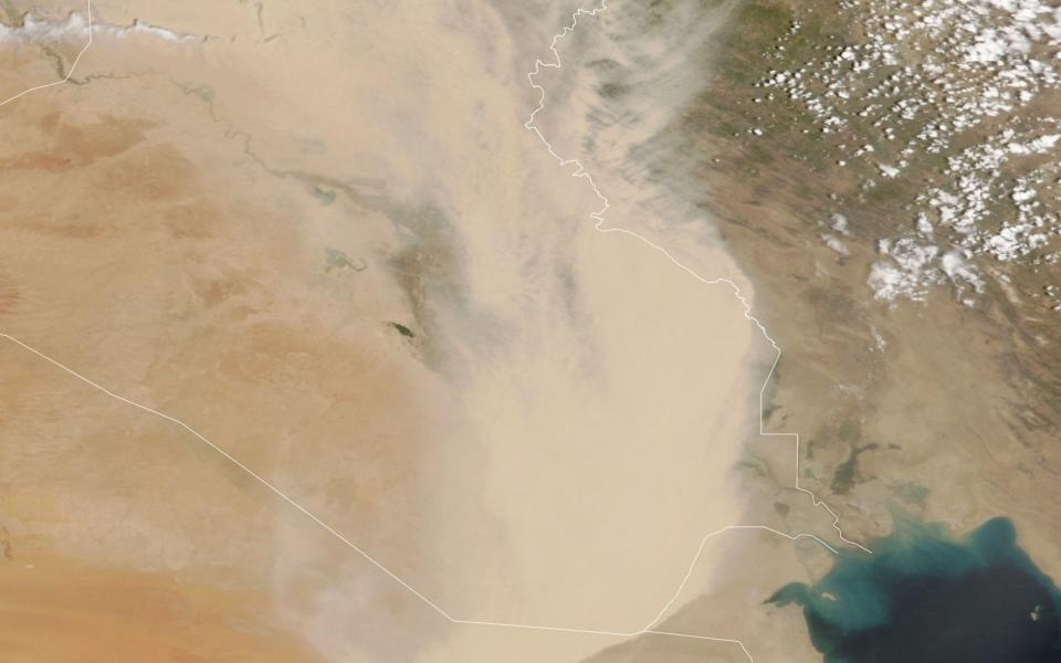 A satellite image shows a dust storm over parts of Iraq and neighbouring countries. Britain could soon experience its own 'blood rain' - Nasa Earth Observatory/AFP