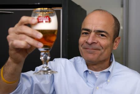 Carlos Brito, chief executive of Anheuser-Busch InBev poses with a Stella Artois beer after the annual shareholders meeting in Brussels, Belgium, April 27, 2016. REUTERS/Francois Lenoir