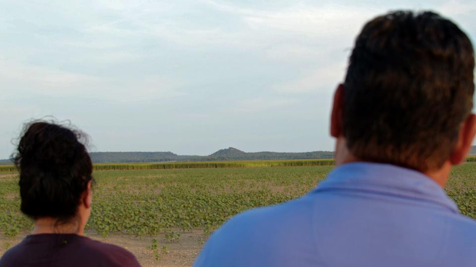 Racheal Starr, left, and Russell Martin, the treasurer and president of the Tonkawa Tribe in northern Oklahoma view Red Mountain in the distance. The central Texas mountain is at the center of the tribe's creation story.