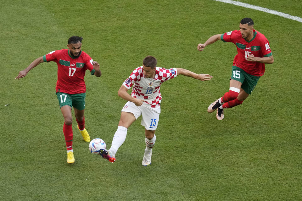 From left, Morocco's Sofiane Boufal, Croatia's Mario Pasalic, and Morocco's Selim Amallah vie for the ball during the World Cup group F soccer match between Morocco and Croatia at the Al Bayt Stadium in Al Khor, Qatar, Wednesday, Nov. 23, 2022. (AP Photo/Darko Vojinovic)