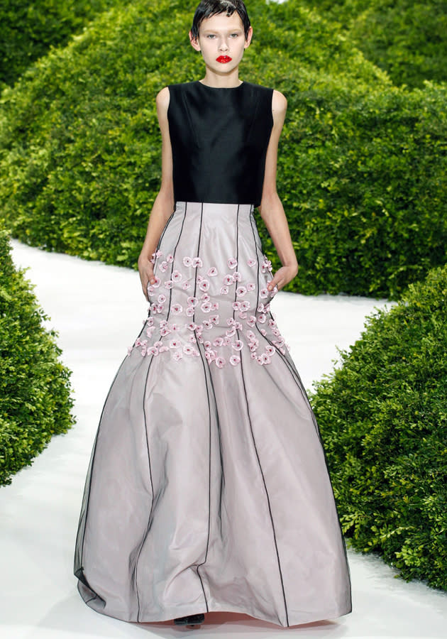 <b>Christian Dior SS13</b><br><br>A model hit the runway in this contrasting dress, with black shift top and shaped skirting embellished with delicate flowers.<br><br>© Rex