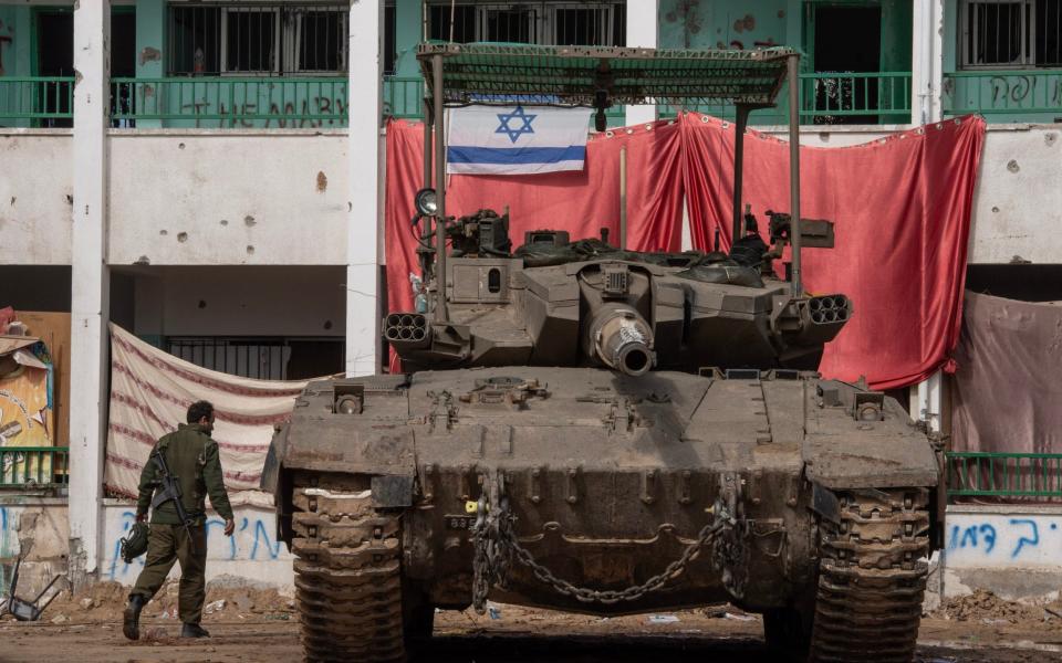 An Israeli Merkava tank in front of a school the soldiers say had been used as a base by Hamas in Khan Younis