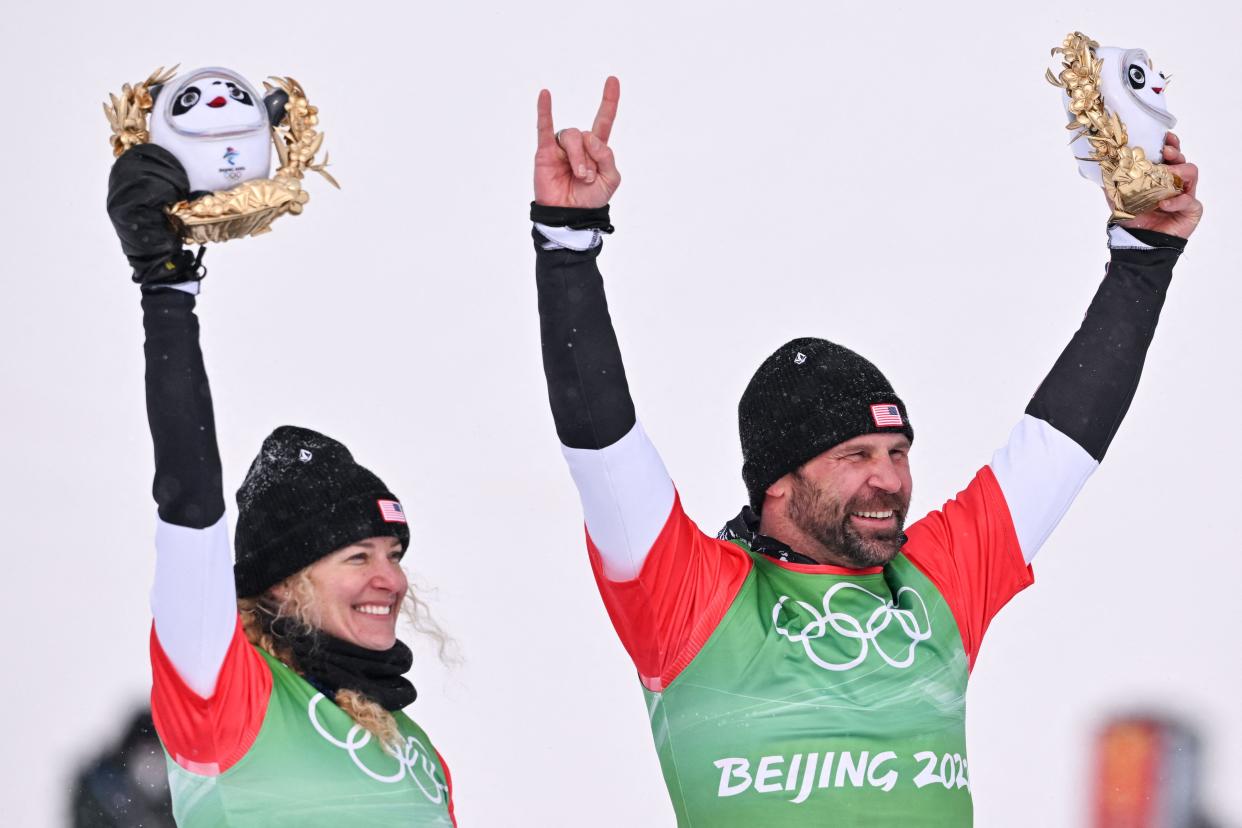 Gold medallists USA's Lindsey Jacobellis and USA's Nick Baumgartner pose on the podium during the venue ceremony after the mixed snowboardcross final during the 2022 Winter Olympics at the Genting Snow Park P & X Stadium in Zhangjiakou, China, on Feb. 12, 2022.
