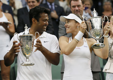 Leander Paes of India and Martina Hingis of Switzerland show off their trophies after winning their Mixed Doubles Final match against Timea Babos of Hungary and Alexander Peya of Austria at the Wimbledon Tennis Championships in London, July 12, 2015. REUTERS/Stefan Wermuth/Files