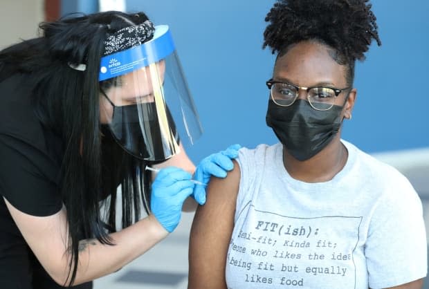 A COVID-19 vaccine is administered to a student in Tennessee in this file photo. Alberta is not planning on offering third vaccine doses for those looking to travel to countries where their immunization status is not recognized.  (Karen Pulfer Focht/Reuters - image credit)