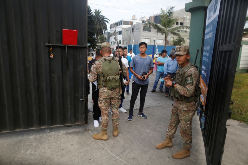 Foto del domingo de un grupo de personas esperando para entrar a un centro de votación en Lima