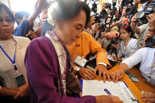 Myanmar opposition leader Aung San Suu Kyi signs the attendance sheet as she arrives at the lower house of parliament to read her parliamentary oath. The Myanmar pro-democracy leader was sworn in as a member of parliament Wednesday, opening a new chapter in the Nobel laureate's near quarter-century struggle against authoritarian rule