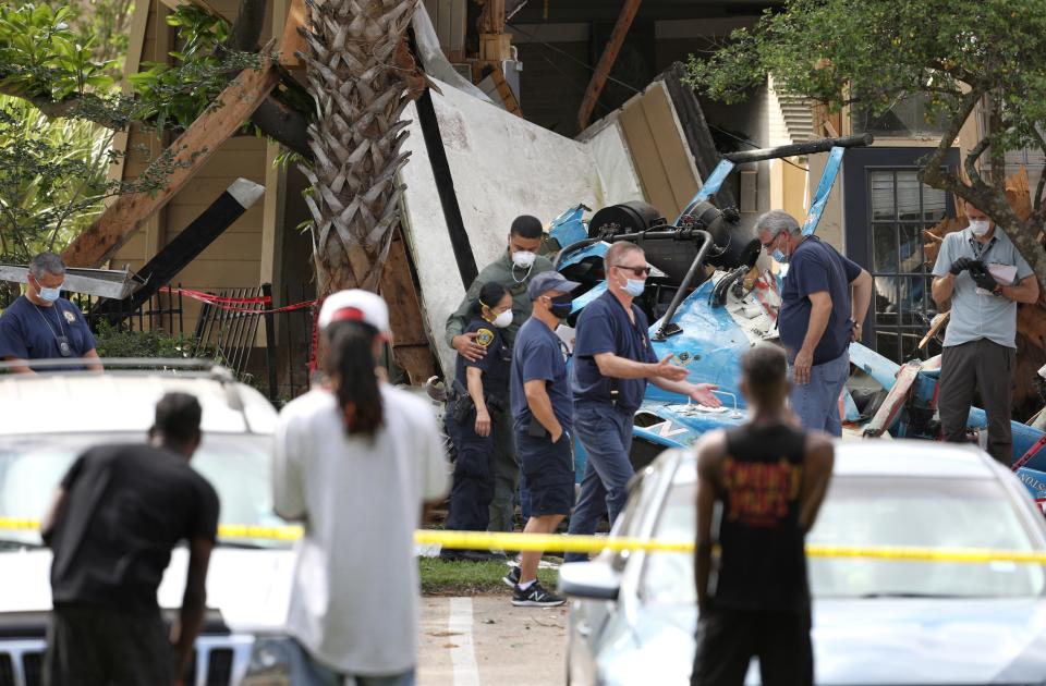 Authorities investigate the scene of a helicopter crash at an apartment complex in Houston, Saturday, May 2, 2020. Houston Police Chief Art Acevedo says the helicopter was carrying a pilot and a tactical flight officer when it went down at an apartment complex in north Houston around 2 a.m. Saturday. The cause of the crash wasn't immediately known. (Jon Shapley/Houston Chronicle via AP)/Houston Chronicle via AP)