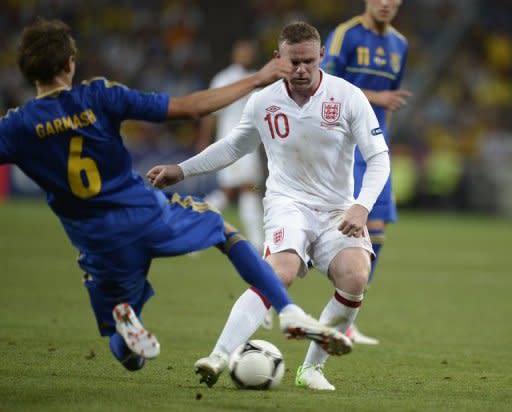 English forward Wayne Rooney (R) is challenged by Ukrainian midfielder Denys Garmash during their Euro 2012 match on June 19. England rode their luck to top Euro 2012 Group D as they beat co-hosts Ukraine 1-0