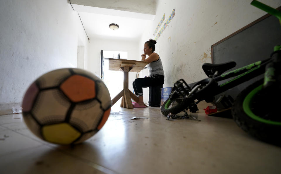 Gabriela Fajardo, a 26-year-old Honduran seeking asylum in the United States, teaches a Zoom class for Central American children living in camps, various shelters and apartments in other parts of Mexico on Friday, Nov. 20, 2020, from a hallway of an aged building in Matamoros, Mexico. Like countless schools, the sidewalk school, as it became known, went to virtual learning amid the coronavirus pandemic, but instead of being hampered by the change, it has blossomed. (AP Photo/Eric Gay)