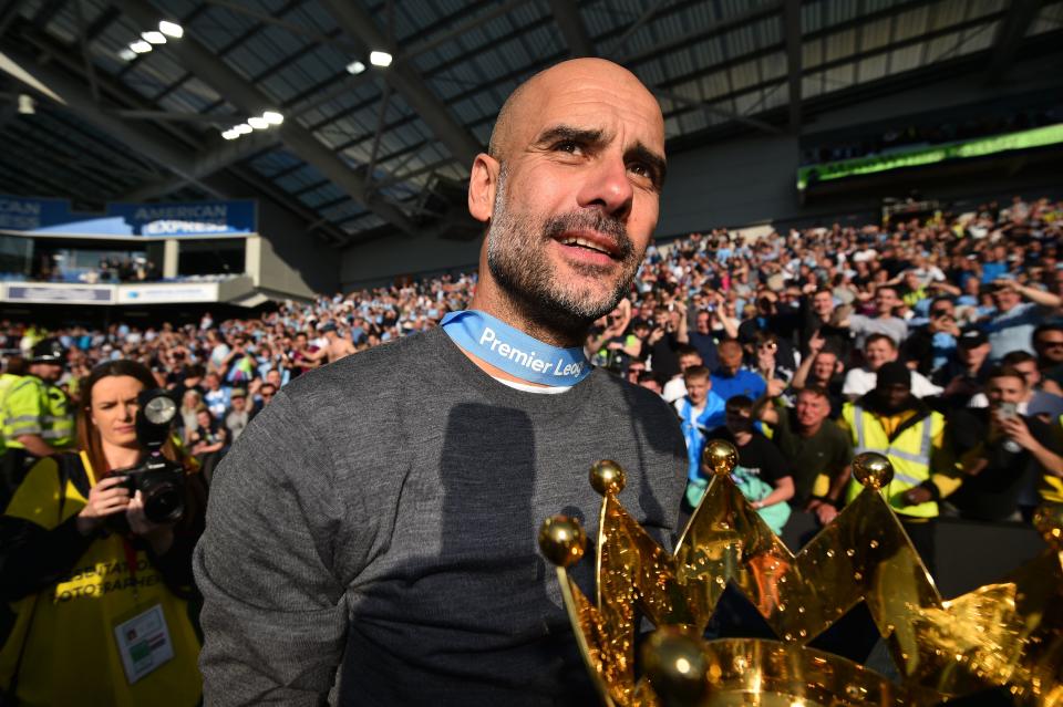 Manchester City's Spanish manager Pep Guardiola shows the Premier League trophy to supporters after their 4-1 victory in the English Premier League football match between Brighton and Hove Albion and Manchester City at the American Express Community Stadium in Brighton, southern England on May 12, 2019. - Manchester City held off a titanic challenge from Liverpool to become the first side in a decade to retain the Premier League on Sunday by coming from behind to beat Brighton 4-1 on Sunday. (Photo by Glyn KIRK / AFP) / RESTRICTED TO EDITORIAL USE. No use with unauthorized audio, video, data, fixture lists, club/league logos or 'live' services. Online in-match use limited to 120 images. An additional 40 images may be used in extra time. No video emulation. Social media in-match use limited to 120 images. An additional 40 images may be used in extra time. No use in betting publications, games or single club/league/player publications. /         (Photo credit should read GLYN KIRK/AFP/Getty Images)