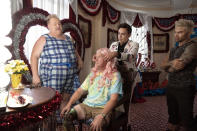This image released by HBO shows Eureka O'Hara, left, and Pastor Craig Duke, of Newburgh, Ind., seated, in a scene from the HBO series "We're Here." Duke’s pastoral duties have been terminated – the result of a bitter rift surfacing in his Indiana church after he sought to demonstrate solidarity by appearing in drag alongside prominent drag queens in the reality show. (Jakes Giles Netter/HBO via AP)