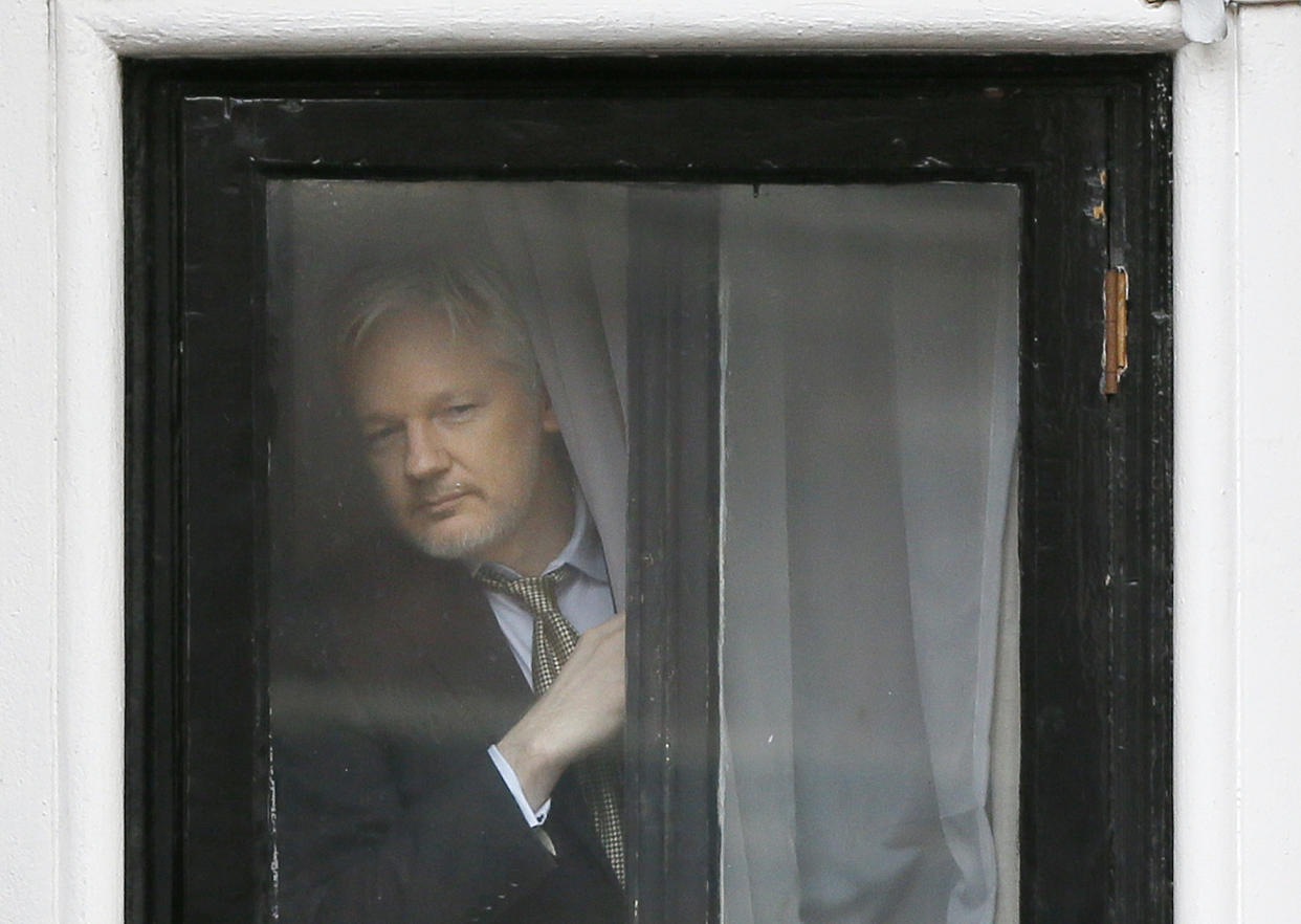 Wikileaks founder Julian Assange appears at the window before speaking on the balcony of the Ecuadorean Embassy in London on Feb. 5, 2016. (Kirsty Wigglesworth/AP)