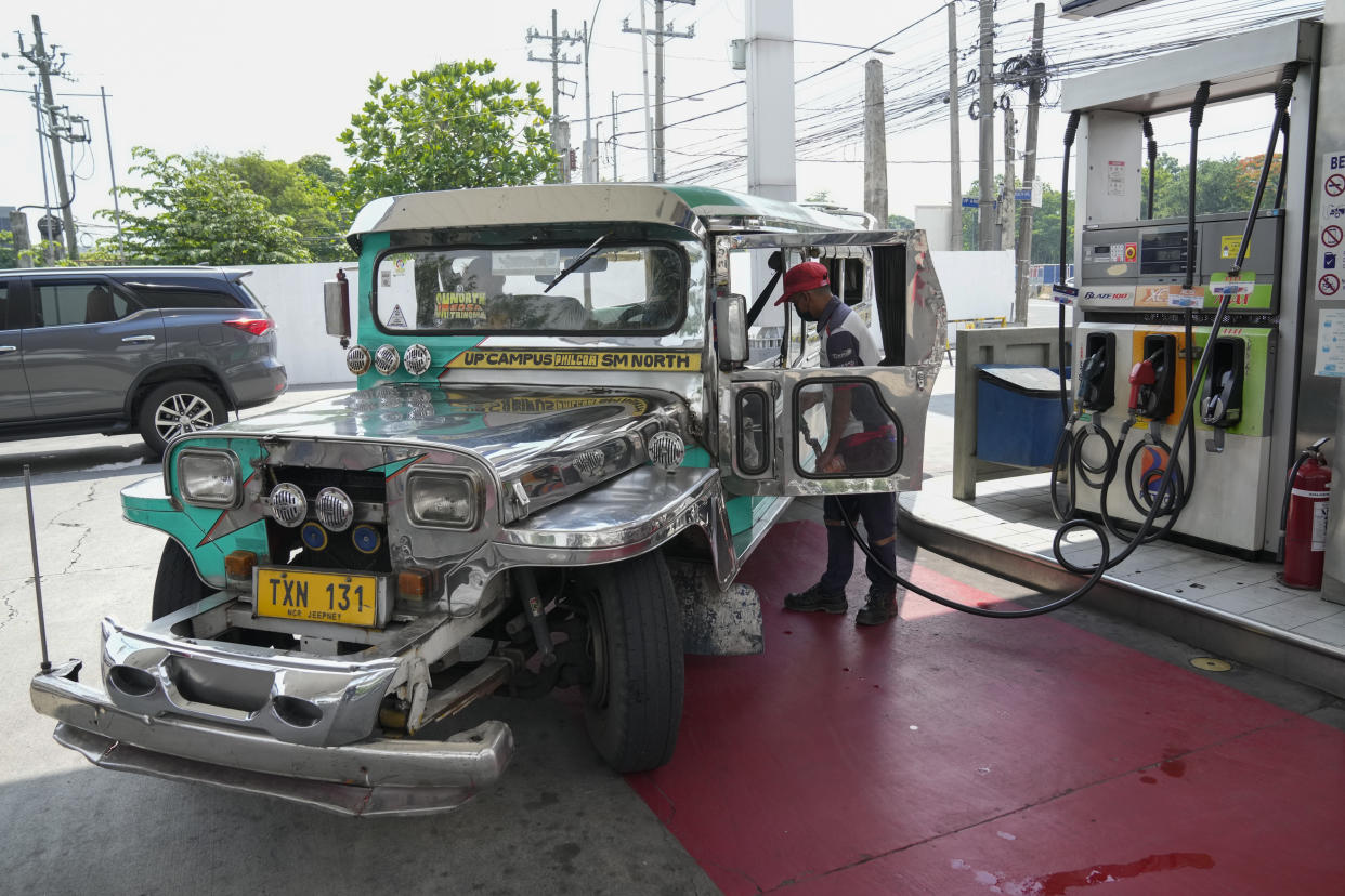 A passenger jeepney driver refuels his vehicle at a gasoline station in Quezon City, Philippines on Monday, June 20, 2022. Around the world, drivers are looking at numbers on the gas pump and rethinking their habits and finances. (AP Photo/Aaron Favila)