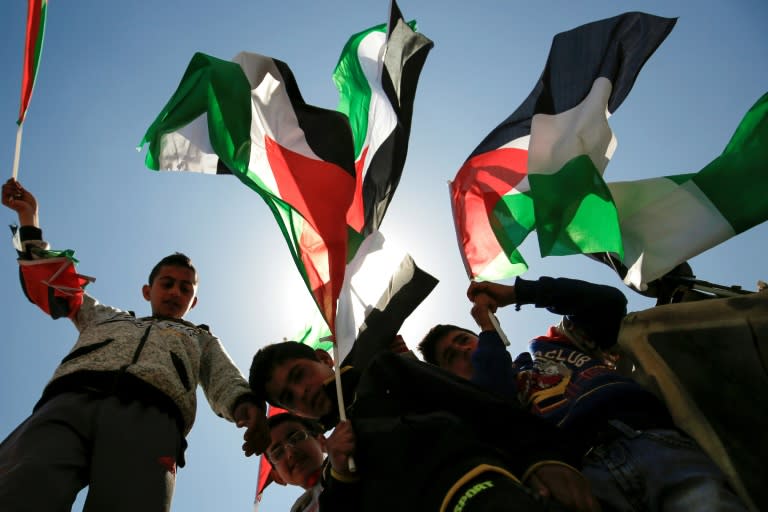 Palestinian children gather with national flags during a demonstration against the construction of Jewish settlements and the confiscation of Palestinian land in the West Bank on March 31, 2017