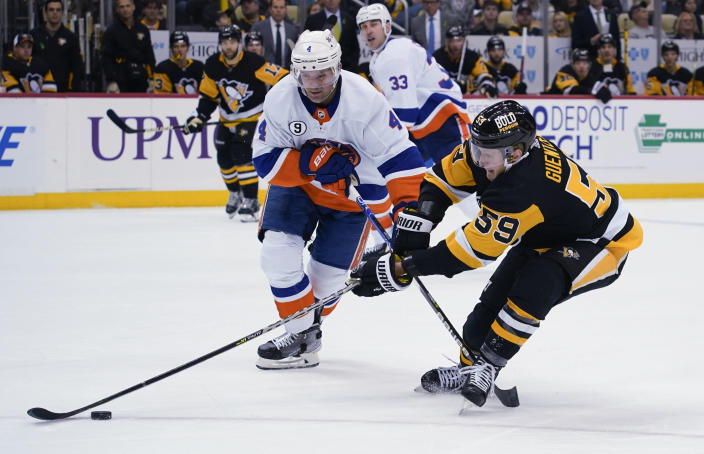 Pittsburgh Penguins' Jake Guentzel (59) tries to get the puck past New York Islanders' Andy Greene (4) during the second period of an NHL hockey game Thursday, April 14, 2022, in Pittsburgh. (AP Photo/Keith Srakocic)