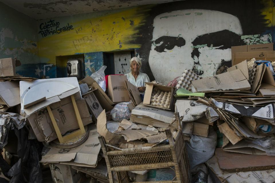 Rosa Maria Gomez, 65, poses for a photo, with a mural of revolutionary leader Ernesto Che Guevara, inside a makeshift shelter in the Petare neighborhood of Caracas, Venezuela, Thursday, May 2, 2019. (AP Photo/Rodrigo Abd)