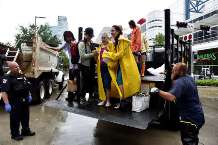 Evacuees are unloaded from the back of an open bed truck at the George R. Brown Convention Center after Hurricane Harvey inundated the Texas Gulf coast with rain causing widespread flooding, in Houston, Texas, U.S. August 27, 2017. REUTERS/Nick Oxford