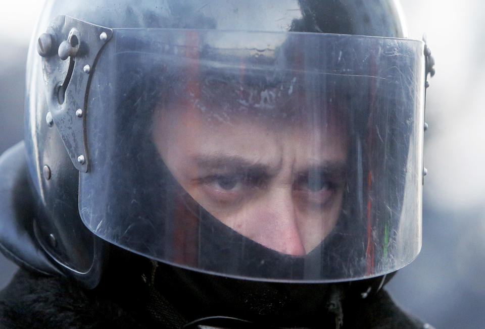 A riot police officer blocks a street against protesters in Kiev, Ukraine, Monday, Jan. 27, 2014. Ukraine's justice minister is threatening to call for a state of emergency unless protesters leave her ministry building, which they occupied during the night. The seizure of the building early Monday underlined how anti-government demonstrators are increasingly willing to take dramatic action as they push for the president's resignation and other concessions. Protesters now occupy four sizable buildings in downtown Kiev, including the city hall. (AP Photo/Efrem Lukatsky)